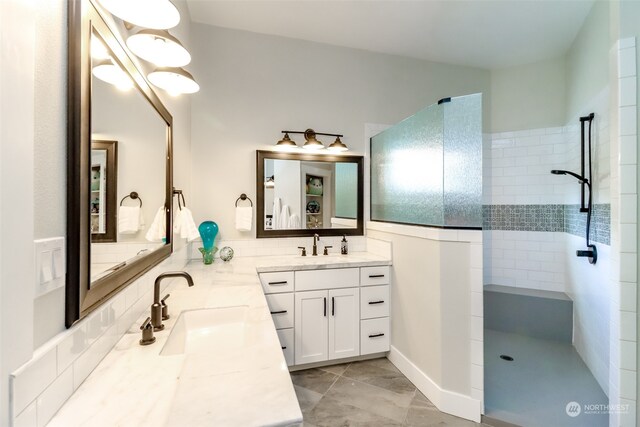 bathroom with vanity and a tile shower