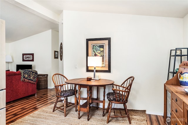 dining room featuring dark hardwood / wood-style flooring and lofted ceiling