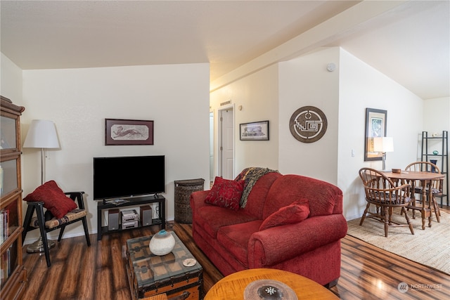 living room featuring dark wood-type flooring and vaulted ceiling