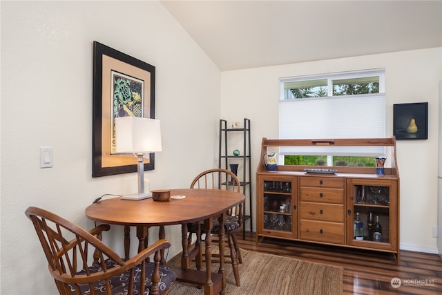 dining space with dark hardwood / wood-style floors and vaulted ceiling