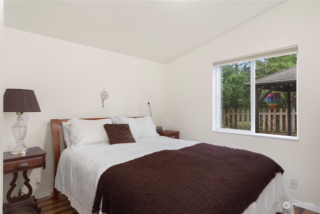 bedroom featuring lofted ceiling and dark hardwood / wood-style flooring