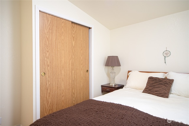 bedroom featuring vaulted ceiling and a closet