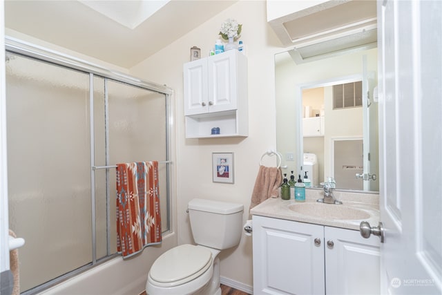 full bathroom featuring shower / bath combination with glass door, vanity, toilet, and vaulted ceiling