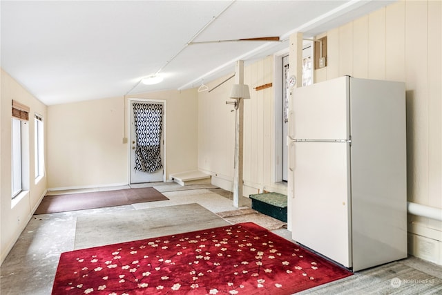 kitchen with white fridge and vaulted ceiling