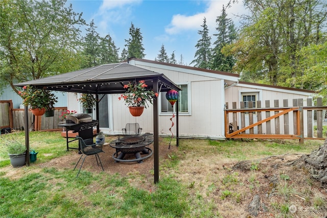 back of house with a gazebo and a fire pit