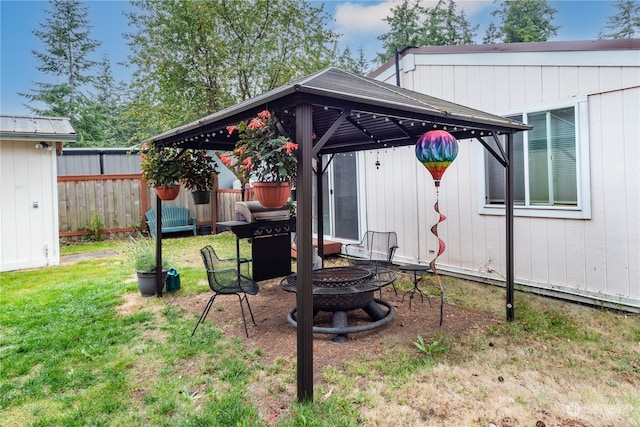 view of yard featuring a fire pit, a storage shed, and a gazebo