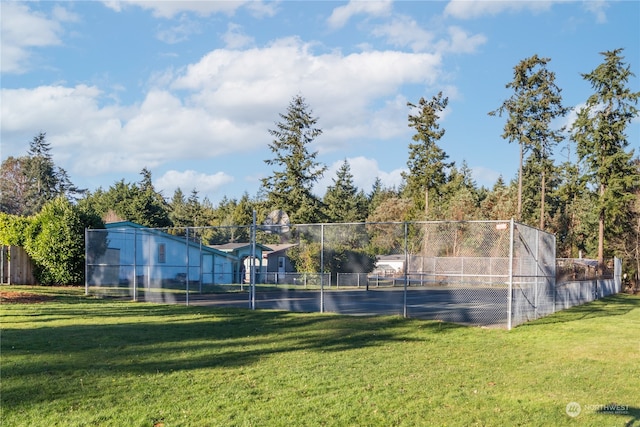 view of tennis court with a lawn