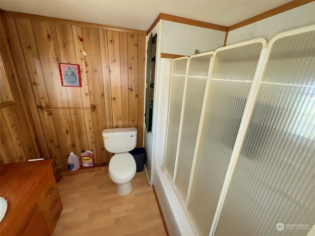 bathroom with vanity, wood walls, an enclosed shower, wood-type flooring, and toilet