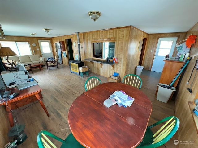 dining area with wood-type flooring and wood walls