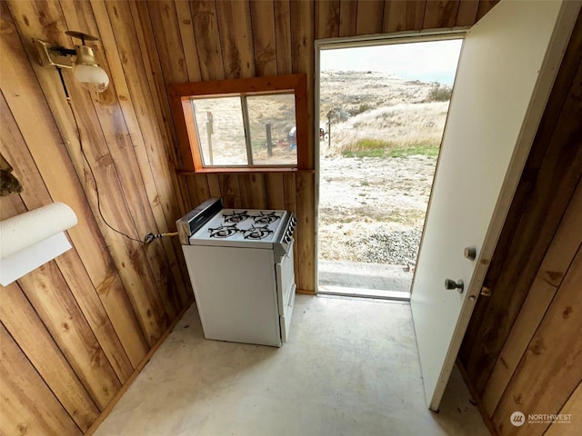 entryway with wooden walls and unfinished concrete floors