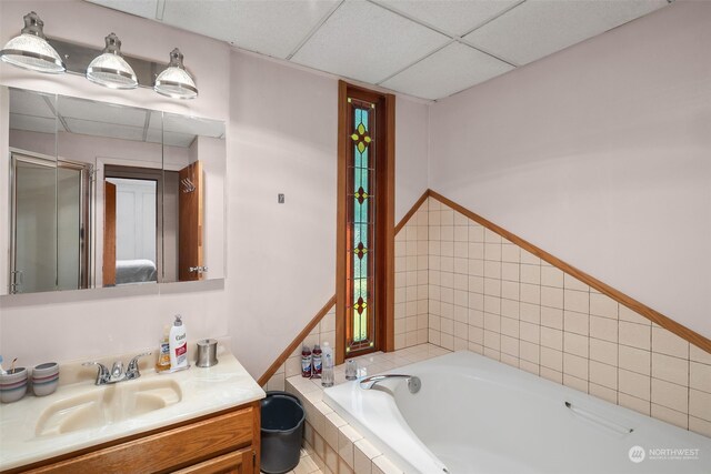 bathroom with vanity, separate shower and tub, and a drop ceiling