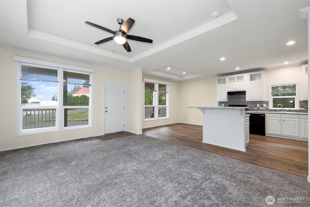 191 E Greenwood Ln, Shelton, WA 98584 - kitchen with black dishwasher, a tray ceiling, open floor plan, a sink, and a kitchen bar