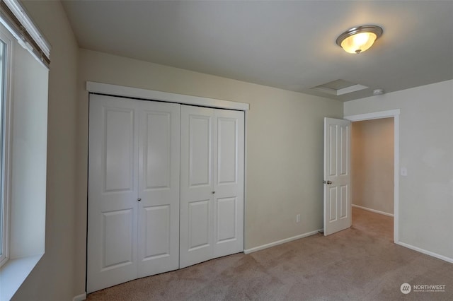 unfurnished bedroom featuring a closet and light colored carpet