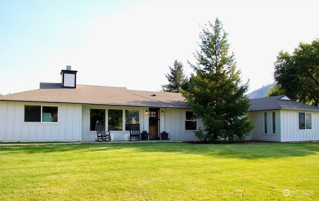 rear view of property with a lawn