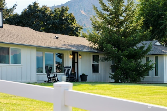 ranch-style home with a mountain view and a front lawn