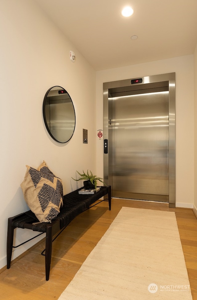 hallway featuring hardwood / wood-style floors and elevator