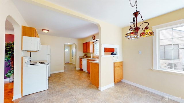 kitchen featuring an inviting chandelier, white appliances, decorative light fixtures, and sink