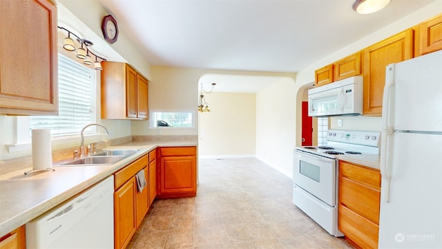 kitchen featuring white appliances, plenty of natural light, decorative light fixtures, and sink