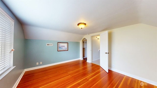 unfurnished room with lofted ceiling and hardwood / wood-style floors