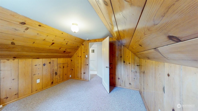 additional living space with light colored carpet, wood walls, vaulted ceiling, and wooden ceiling