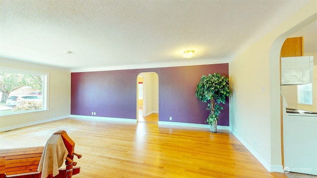 spare room with a textured ceiling and hardwood / wood-style floors