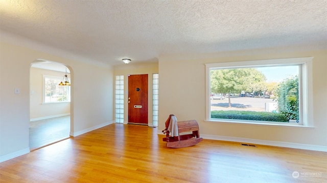 entryway featuring a chandelier, a textured ceiling, and hardwood / wood-style floors