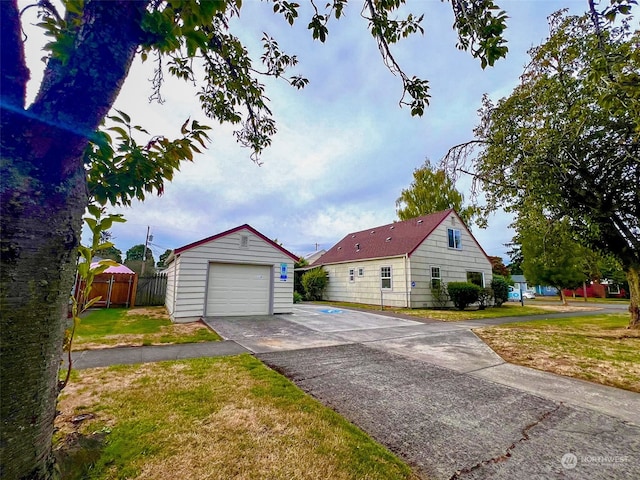 view of front of home with an outdoor structure, a garage, and a front yard