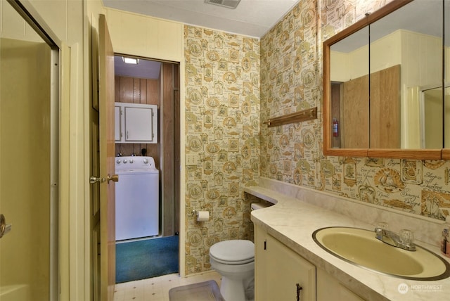 bathroom featuring washer / clothes dryer, toilet, and vanity