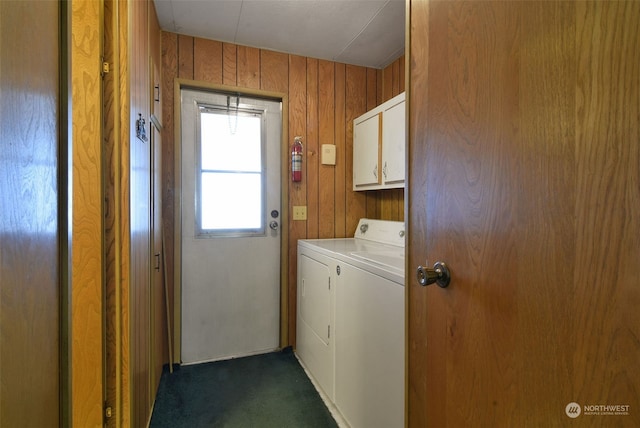 washroom featuring cabinets, dark colored carpet, and wooden walls