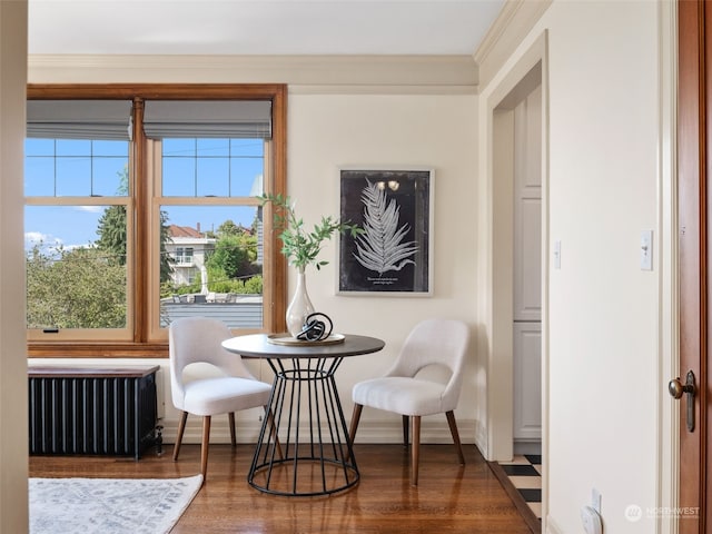 sitting room with ornamental molding, radiator heating unit, and hardwood / wood-style flooring