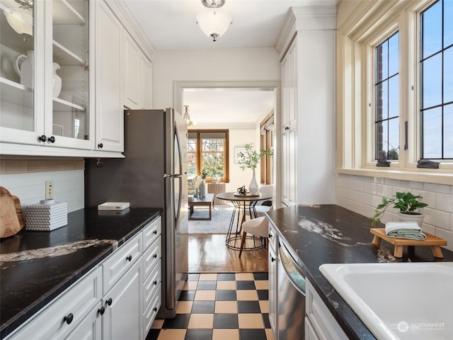 kitchen with dishwasher, tasteful backsplash, dark stone countertops, and white cabinets