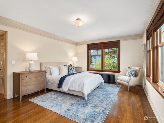 bedroom with radiator heating unit, dark wood-type flooring, and ornamental molding