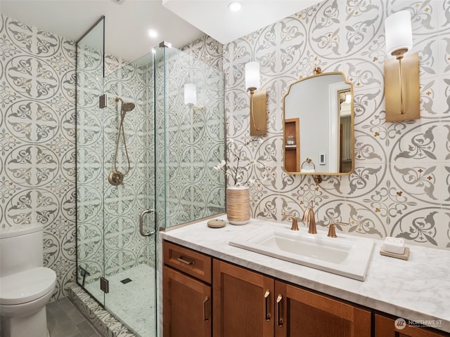 bathroom featuring vanity, toilet, and a shower with shower door