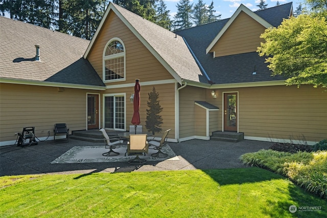 rear view of property with a lawn and a patio area