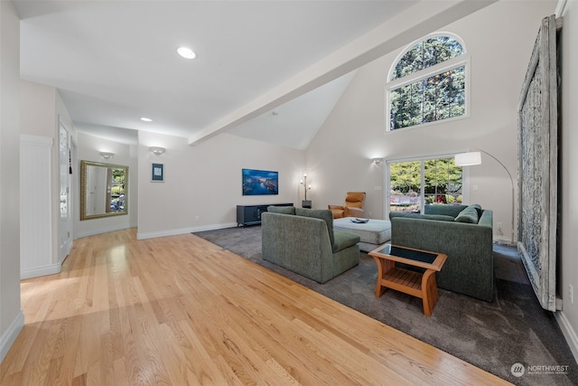 living room featuring beamed ceiling, high vaulted ceiling, and light hardwood / wood-style flooring