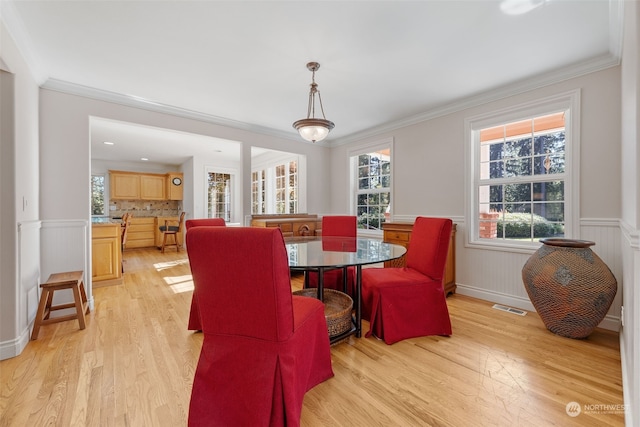 dining space featuring light hardwood / wood-style floors and ornamental molding