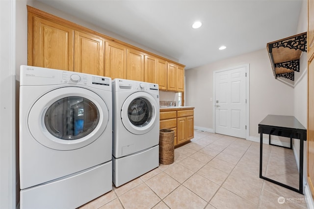 laundry area featuring light tile patterned flooring, cabinets, and independent washer and dryer