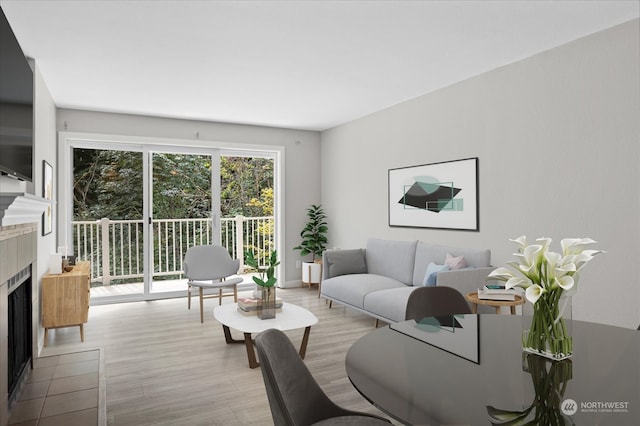 living room featuring light hardwood / wood-style flooring and a tiled fireplace