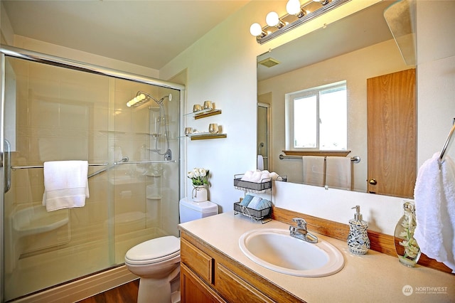 bathroom featuring vanity, a shower with shower door, toilet, and hardwood / wood-style flooring