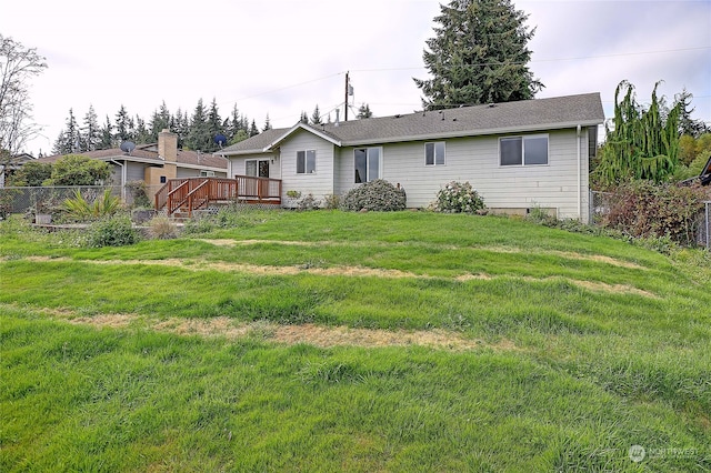 back of property with a lawn and a wooden deck