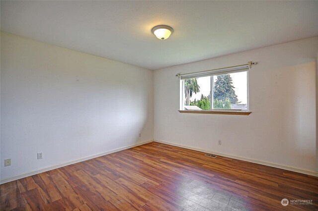 unfurnished room featuring dark wood-type flooring