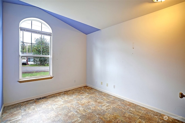 spare room featuring vaulted ceiling