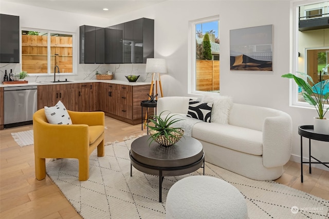 living room with light hardwood / wood-style floors and sink