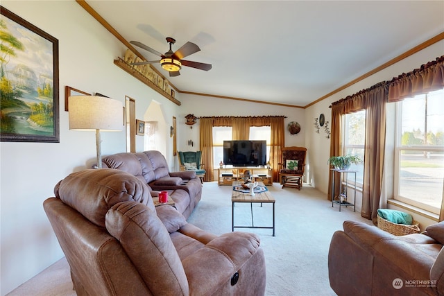 living room with ornamental molding, vaulted ceiling, light colored carpet, and ceiling fan