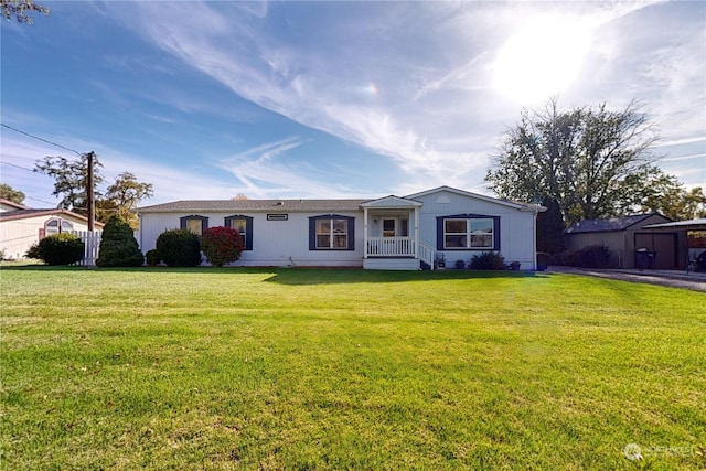 ranch-style house featuring a storage shed and a front lawn