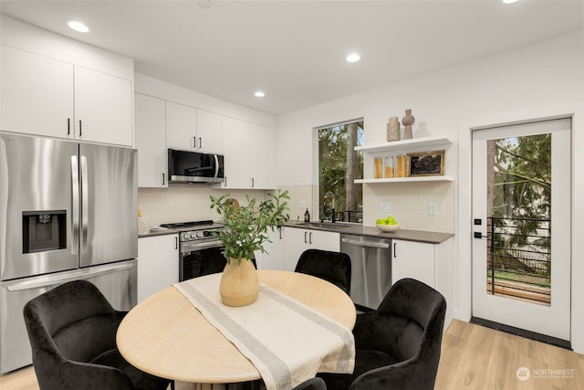 kitchen with white cabinetry, plenty of natural light, stainless steel appliances, and sink