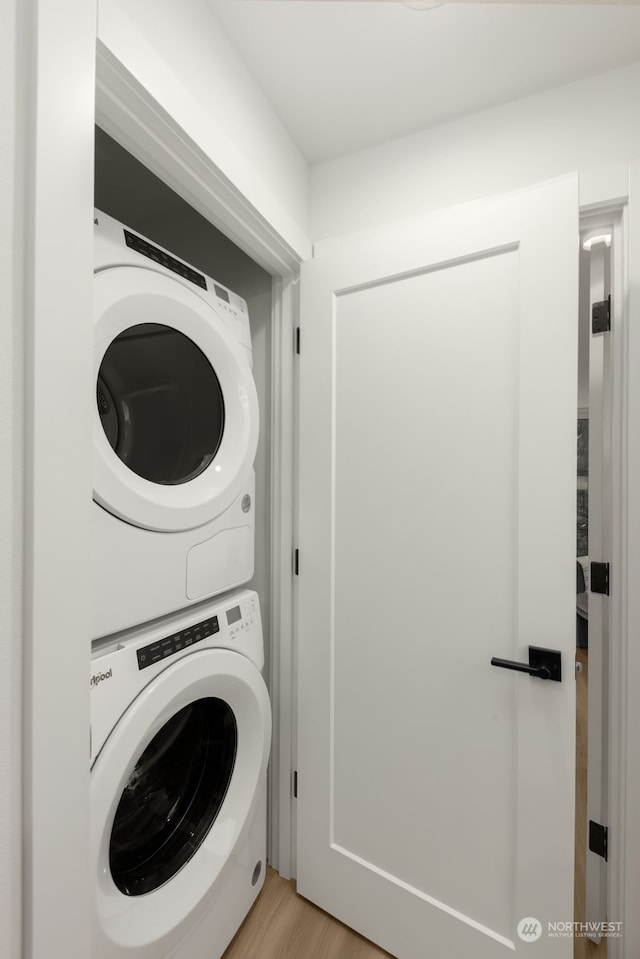 washroom featuring stacked washer and clothes dryer and light wood-type flooring