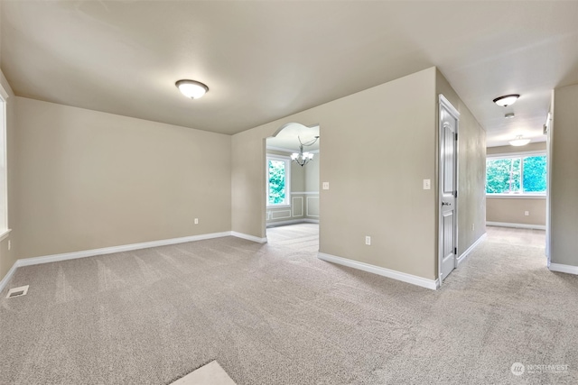 carpeted spare room featuring plenty of natural light