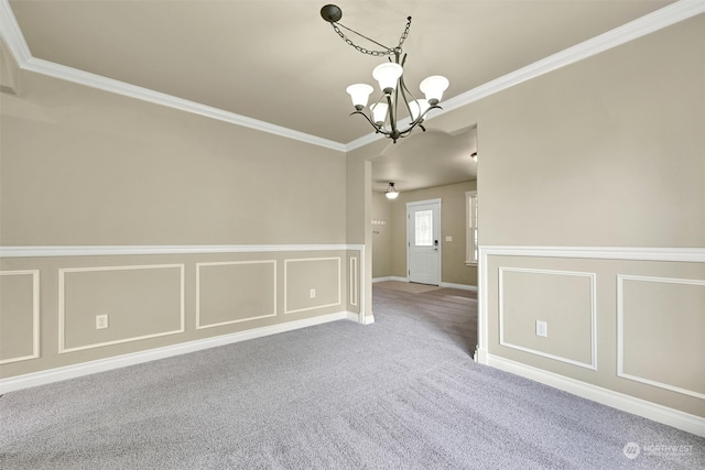 carpeted spare room with a notable chandelier and ornamental molding