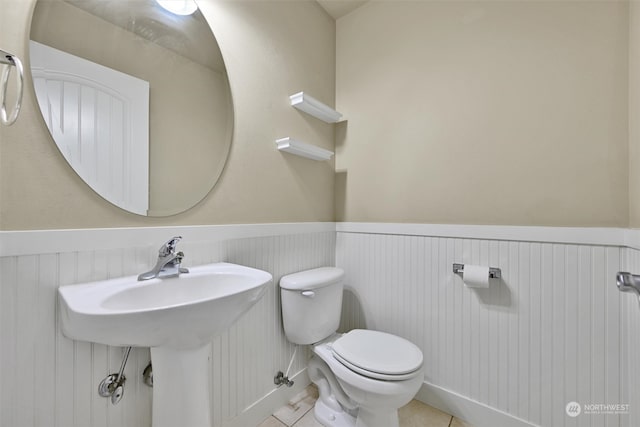 bathroom with toilet and tile patterned floors